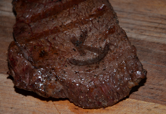 Brand steaks with a custom branding iron the grill.