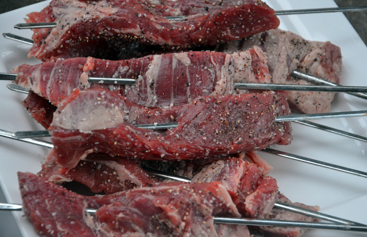 Thread 1" x 3" slices of flank steak onto metal skewers and grill.