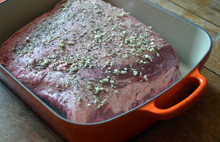 Cover brisket with minced garlic and freshly cracked black pepper.