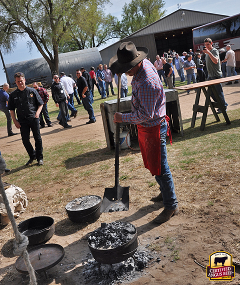 Kent Rollins tends the fire for a cowboy meal.